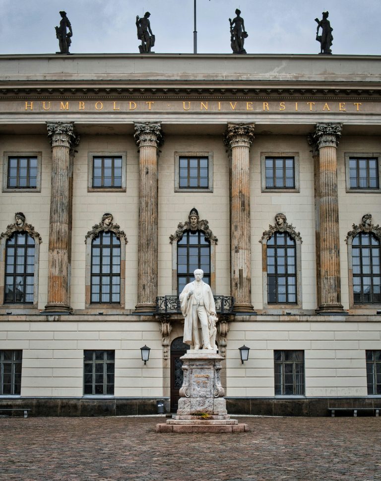 Facade of Humboldt University in Berlin featuring statues and classical architecture.